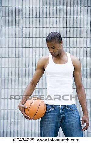 Portrait of a young African American man holding a basketball. View Large Photo Image Stock Photo - Portrait of a young African American man holding a basketball. . Fotosearch
