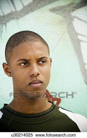 Portrait of a young African American man in front of a graffiti covered wall View Large Photo Image Stock Photography - Portrait of a young African American man in front of a graffiti covered wall. Fotosearch