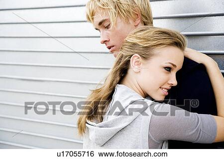 Portrait of a young couple leaning against a metallic wall View Large Photo Image Stock Photograph - Portrait of a young couple leaning against a metallic wall . Fotosearch