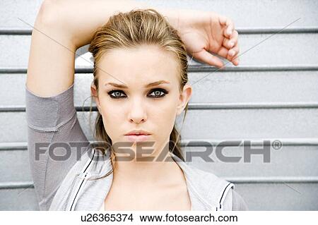 Portrait of a young girl leaning against a metallic wall View Large Photo Image Picture - Portrait of a young girl leaning against a metallic wall . Fotosearch