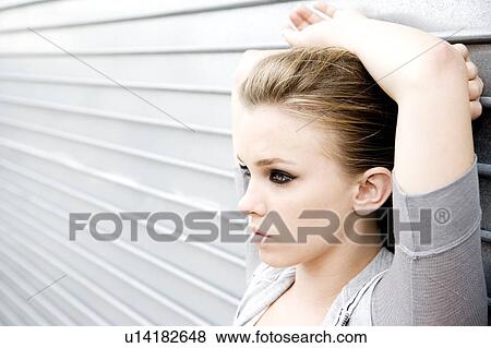 Portrait of a young girl leaning against a metallic wall View Large Photo Image Stock Photo - Portrait of a young girl leaning against a metallic wall . Fotosearch