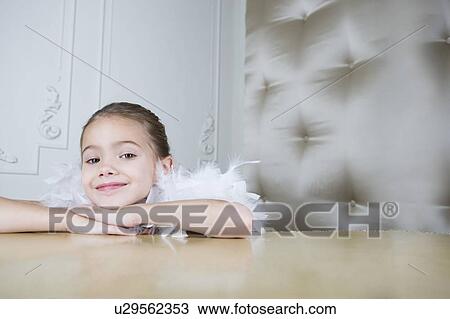 Stock Image - Portrait of a young girl with a feather boa in dressing up clothes. Fotosearch