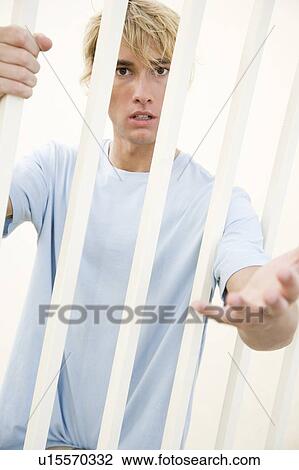 Portrait of a young man behind bars View Large Photo Image Stock Image - Portrait of a young man behind bars. Fotosearch
