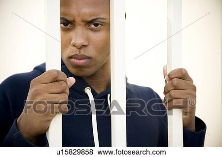 Portrait of a young man behind bars View Large Photo Image Stock Photo - Portrait of a young man behind bars. Fotosearch