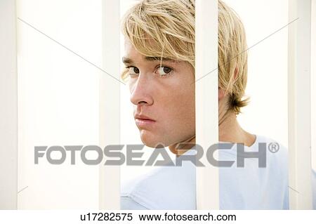 Portrait of a young man behind bars View Large Photo Image Stock Photography - Portrait of a young man behind bars. Fotosearch