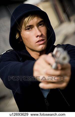 Portrait of a young man holding a gun View Large Photo Image Stock Photo - Portrait of a young man holding a gun . Fotosearch