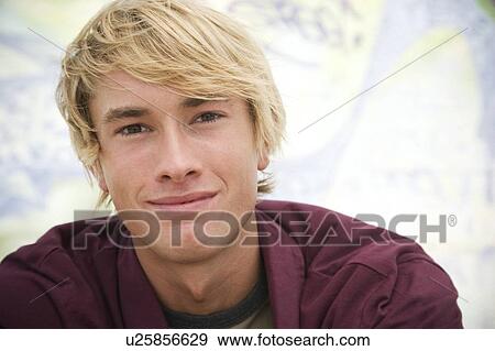Portrait of a young man in front of a graffiti covered wall View Large Photo Image Stock Photo - Portrait of a young man in front of a graffiti covered wall. Fotosearch