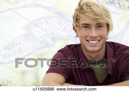 Portrait of a young man in front of a graffiti covered wall View Large Photo Image Stock Photograph - Portrait of a young man in front of a graffiti covered wall. Fotosearch