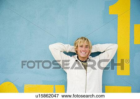 Portrait of a young man leaning against a green painted wall View Large Photo Image Stock Photo - Portrait of a young man leaning against a green painted wall . Fotosearch