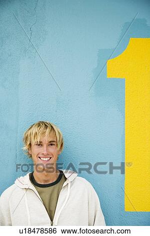Portrait of a young man leaning against a green painted wall View Large Photo Image Stock Photograph - Portrait of a young man leaning against a green painted wall . Fotosearch