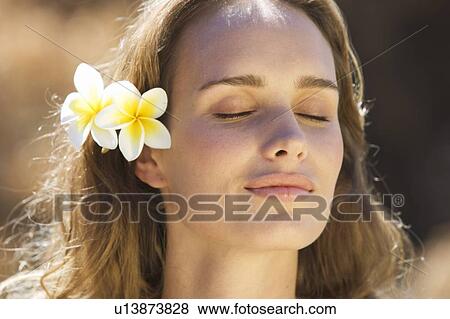 Portrait of a young woman with flowers in her hair, close-up View Large Photo Image Stock Photo - Portrait of a young woman with flowers in her hair, close-up. Fotosearch