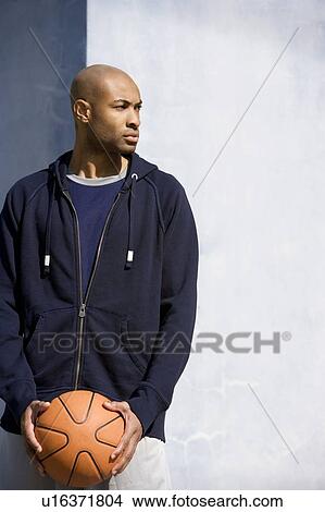 Picture - Portrait of young African American man holding a basketball. Fotosearch