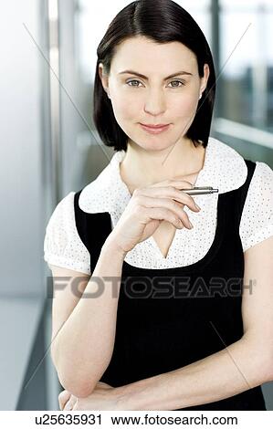 Stock Image - Portrait of young businesswoman or secretary holding a pen . Fotosearch