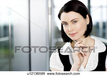 Stock Photo - Portrait of young businesswoman or secretary holding a pen . Fotosearch