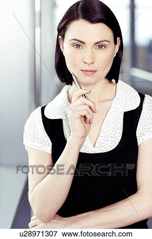 Stock Photo - Portrait of young businesswoman or secretary holding a pen . Fotosearch