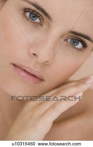Portrait of young woman holding her hand to her face View Large Photo Image Stock Image - Portrait of young woman holding her hand to her face. Fotosearch