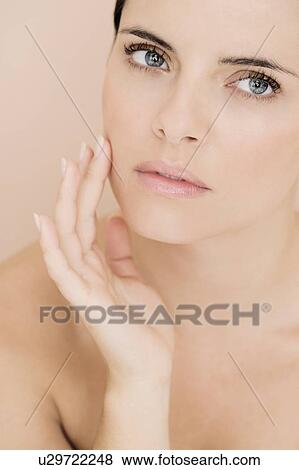 Stock Photo - Portrait of young woman touching her cheek. Fotosearch