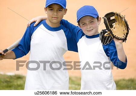 Stock Photograph - portrait two boys posing for camera at baseball match. Fotosearch