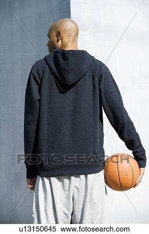 Rear view portrait of young African American man holding a basketball View Large Photo Image Stock Photography - Rear view portrait of young African American man holding a basketball. Fotosearch