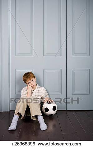 sad little boy sitting on floor with football View Large Photo Image Stock Photograph - sad little boy sitting on floor with football. Fotosearch