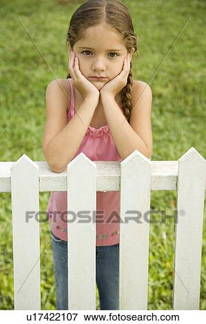 sad little girl leaning on fence View Large Photo Image Stock Photo - sad little girl leaning on fence . Fotosearch