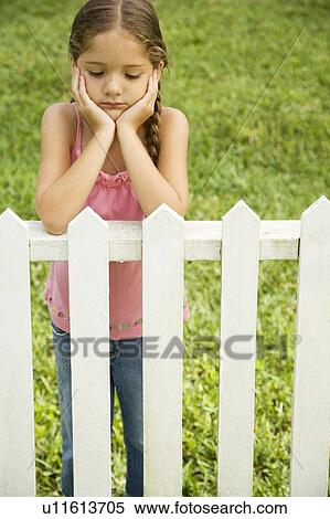 sad little girl leaning on fence View Large Photo Image Stock Photography - sad little girl leaning on fence . Fotosearch