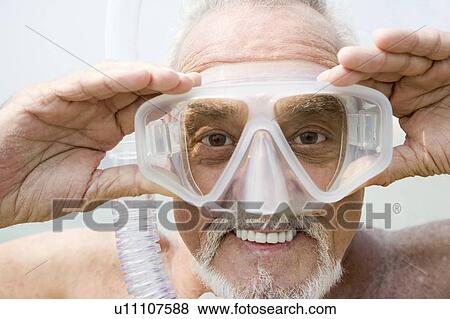 Stock Photo - Senior man with snorkel gear at the beach . Fotosearch
