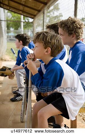 Stock Image - Side view little league baseball team waiting to bat. Fotosearch