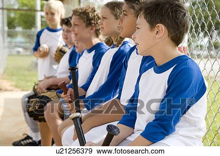 Stock Photo - Side view little league baseball team waiting to bat. Fotosearch