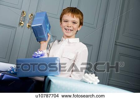 Picture - smiling boy holding present. Fotosearch