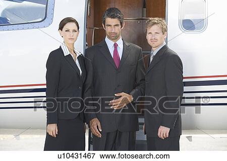 Three business colleagues standing by a plane View Large Photo Image Stock Photo - Three business colleagues standing by a plane. Fotosearch