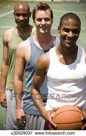Three men standing on an outdoor basketball court View Large Photo Image Stock Photo - Three men standing on an outdoor basketball court . Fotosearch