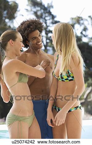 Three teenage friends having fun by a swimming pool View Large Photo Image Stock Image - Three teenage friends having fun by a swimming pool. Fotosearch