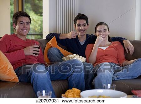 Three teenage friends watching television View Large Photo Image Stock Image - Three teenage friends watching television. Fotosearch