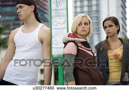 Three teenagers standing at a bus stop View Large Photo Image Stock Image - Three teenagers standing at a bus stop. Fotosearch