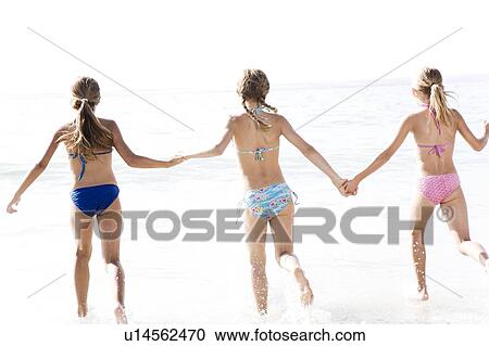 Three young girls running into the sea View Large Photo Image Stock Image - Three young girls running into the sea. Fotosearch