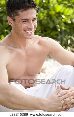 Topless man sitting cross-legged on a rock in the sun View Large Photo Image Stock Photo - Topless man sitting cross-legged on a rock in the sun. Fotosearch
