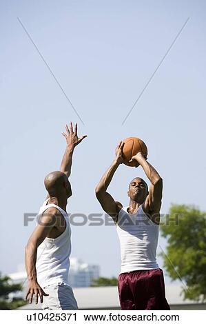 Two African American men jumping for a basketball View Large Photo Image Stock Image - Two African American men jumping for a basketball. Fotosearch