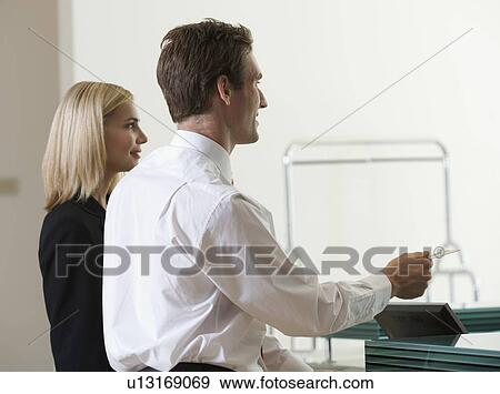 Stock Photo - Two business colleagues checking in/out. Fotosearch