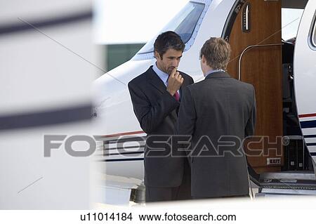 Two business colleagues shaking hands before departure View Large Photo Image Picture - Two business colleagues shaking hands before departure. Fotosearch