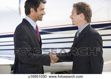 Two business colleagues shaking hands before departure View Large Photo Image Stock Image - Two business colleagues shaking hands before departure. Fotosearch