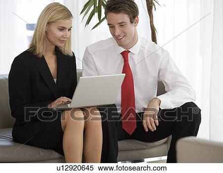 Stock Photography - Two business colleagues working on a laptop. Fotosearch