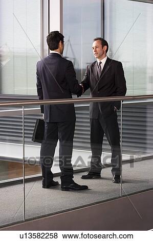 Stock Photo - Two businessmen shaking hands. Fotosearch