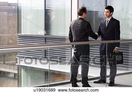 Stock Photo - Two businessmen shaking hands. Fotosearch