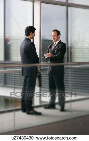 Two businessmen talking View Large Photo Image Stock Image - Two businessmen talking. Fotosearch