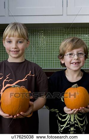Two children holding orange Hallowe'en pumpkins View Large Photo Image Stock Photo - Two children holding orange Hallowe'en pumpkins. Fotosearch