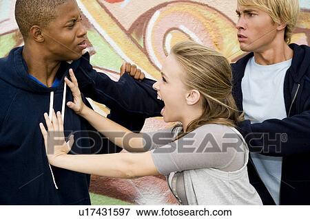 Two men fighting over a girl in front of a graffiti covered wall View Large Photo Image Stock Photo - Two men fighting over a girl in front of a graffiti covered wall . Fotosearch