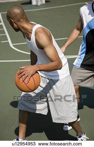Two men playing basketball on a green urban outside court View Large Photo Image Stock Image - Two men playing basketball on a green urban outside court. Fotosearch