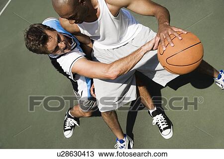 Two men playing basketball on a green urban outside court View Large Photo Image Stock Image - Two men playing basketball on a green urban outside court. Fotosearch