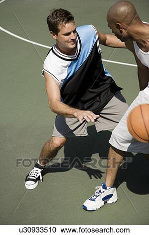 Two men playing basketball on a green urban outside court View Large Photo Image Stock Image - Two men playing basketball on a green urban outside court. Fotosearch